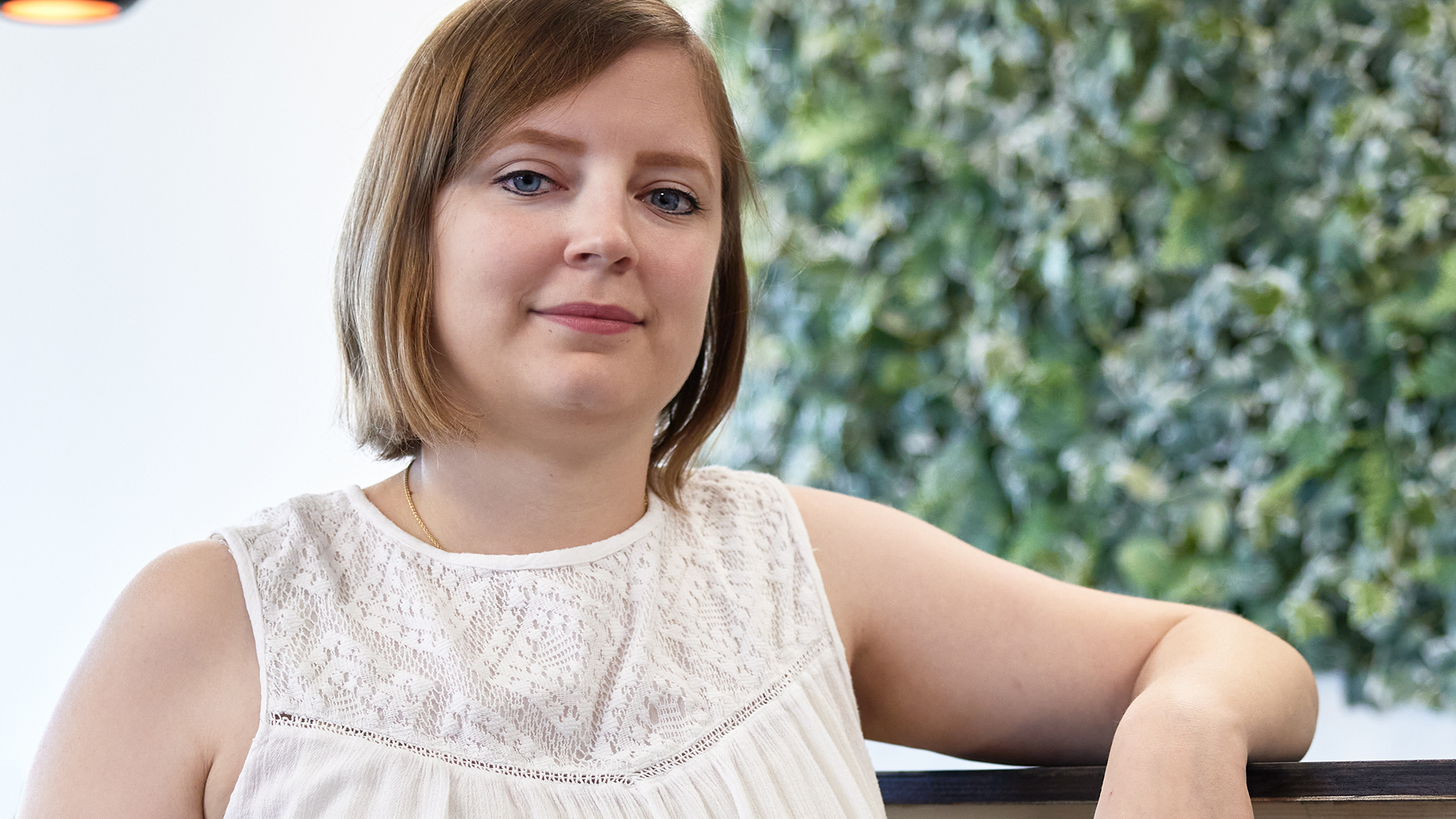 Valérie Glutz mit weisser Bluse und einem Arm aufgestützt auf Bürokorpus