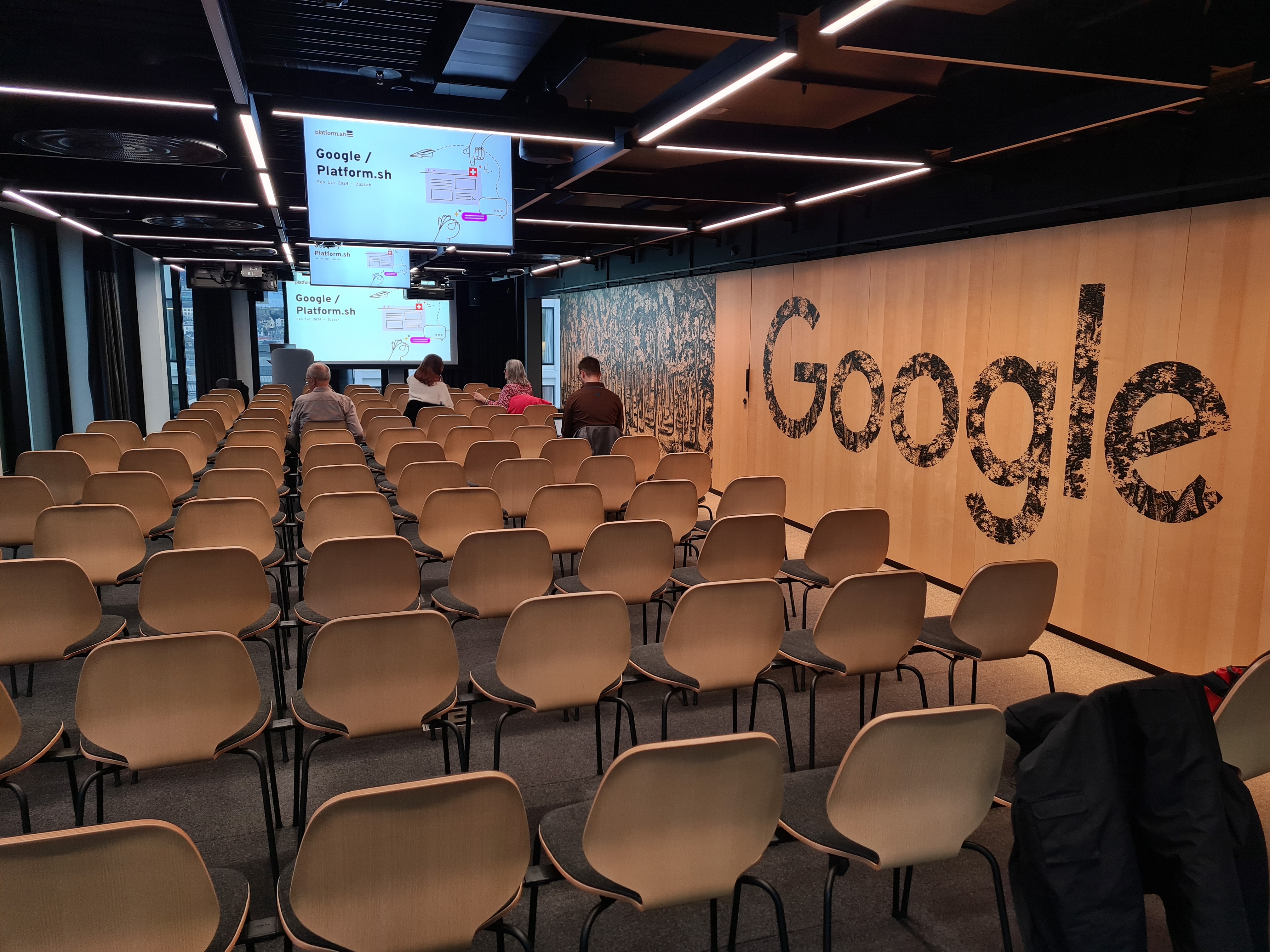 Grosser Seminarraum mit vielen Stühlen und Google Schriftzug an der Wand.