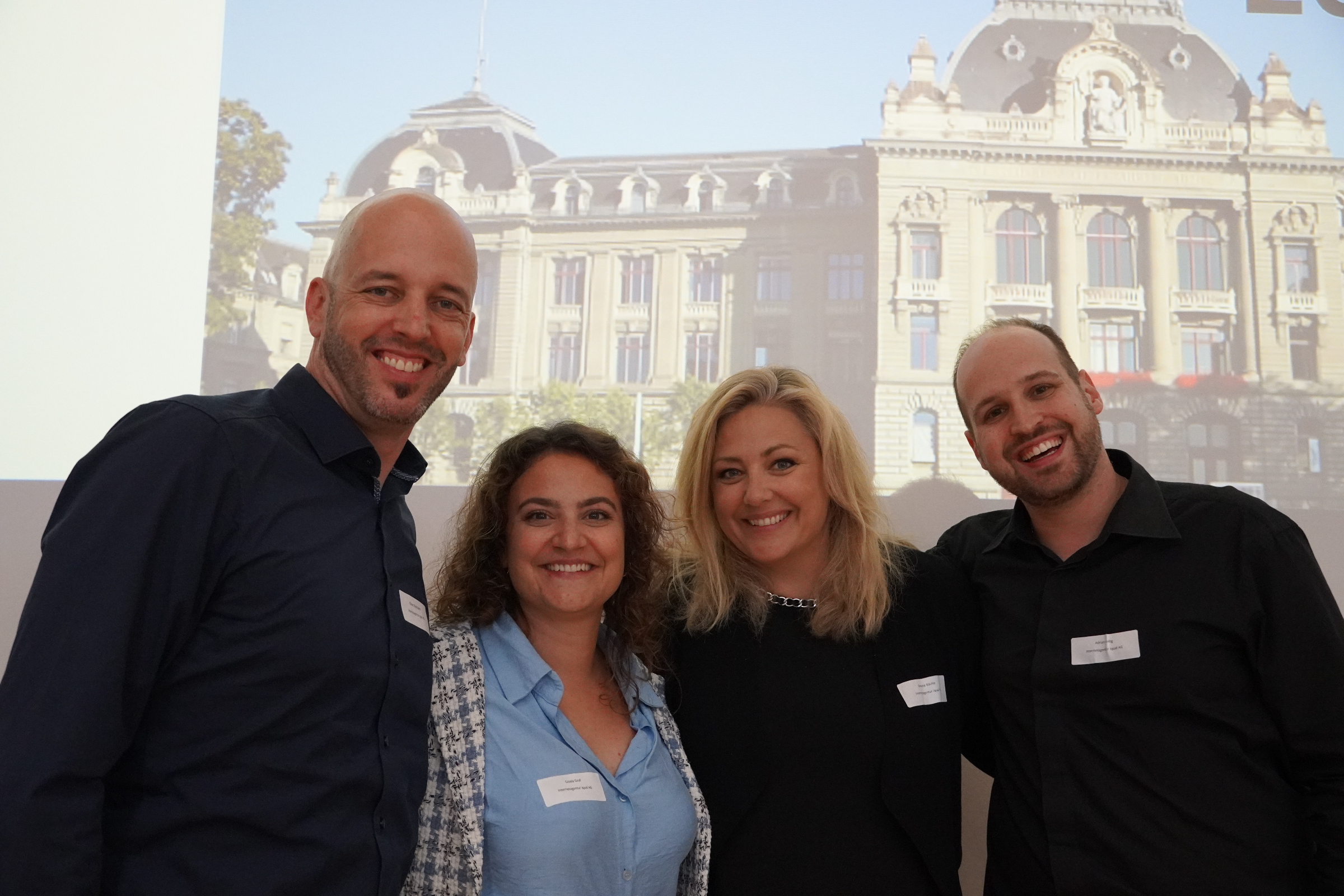 Gruppenbild von iqual Mitarbeitenden die in die Kamera lächeln Gruppenbild von iqual Mitarbeitenden die in die Kamera lächeln