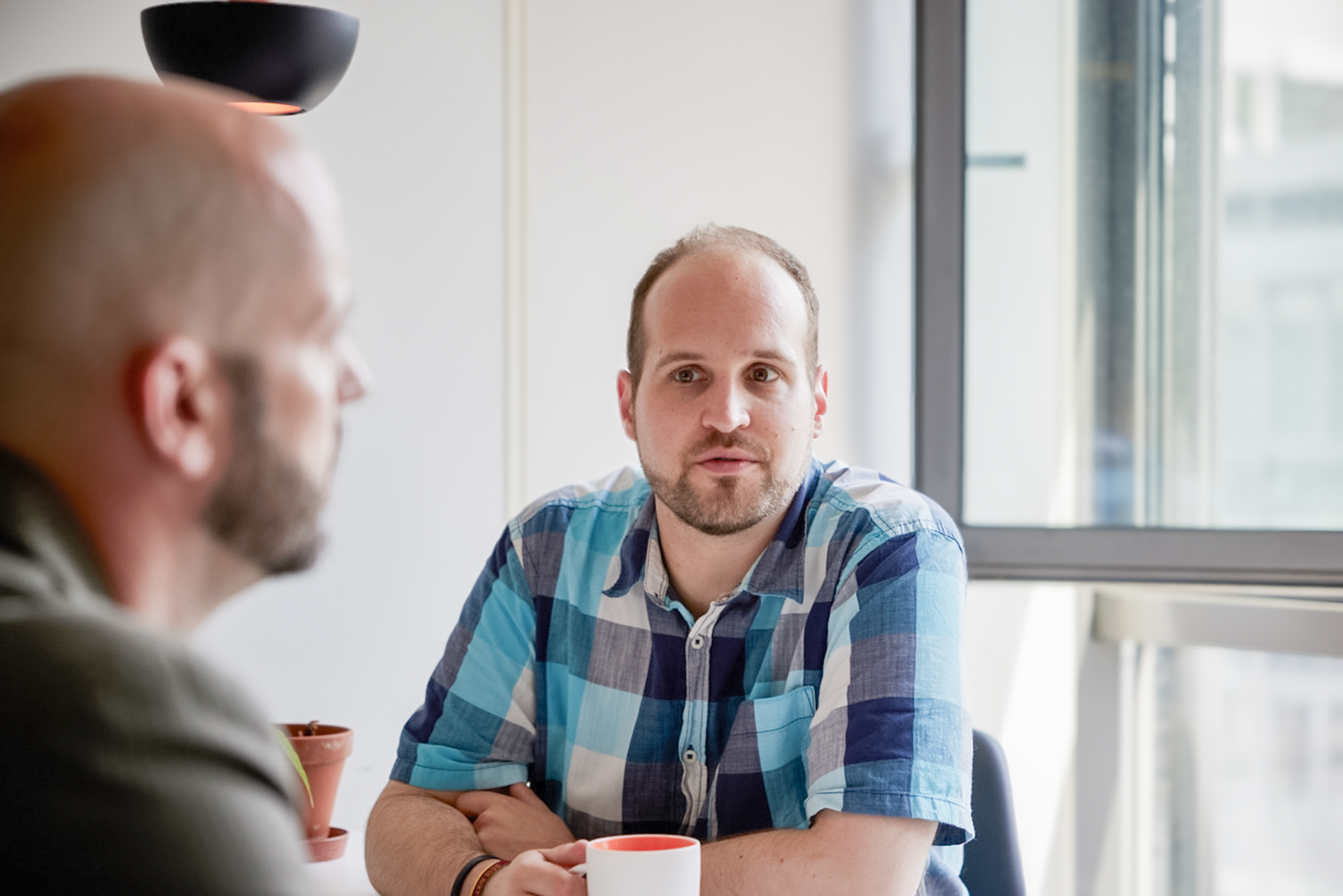 iqual Mitarbeiter sitzt am Tisch