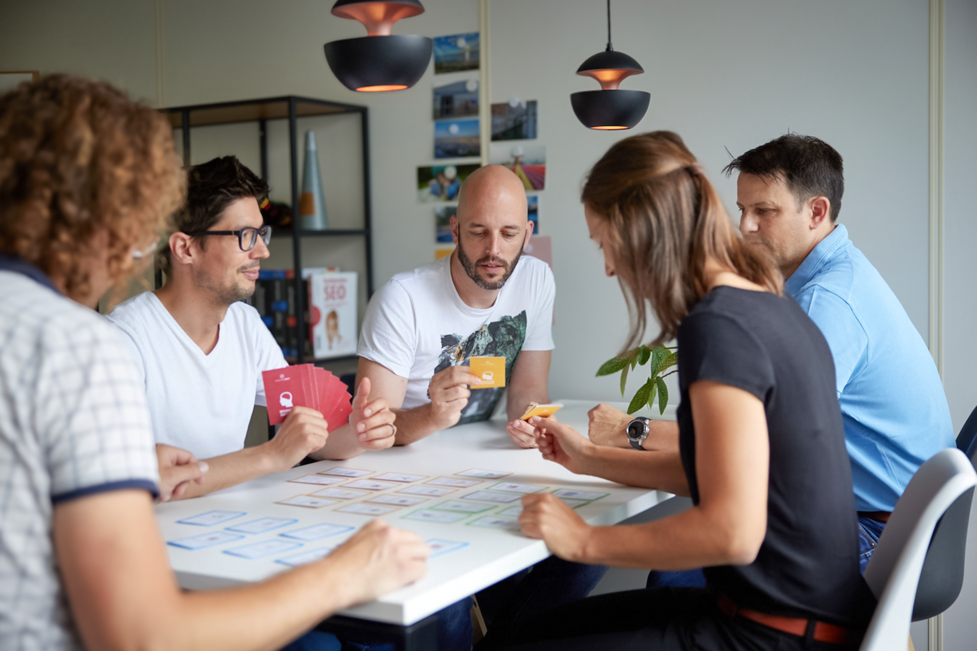 iqual Mitarbeitende spielen Karte