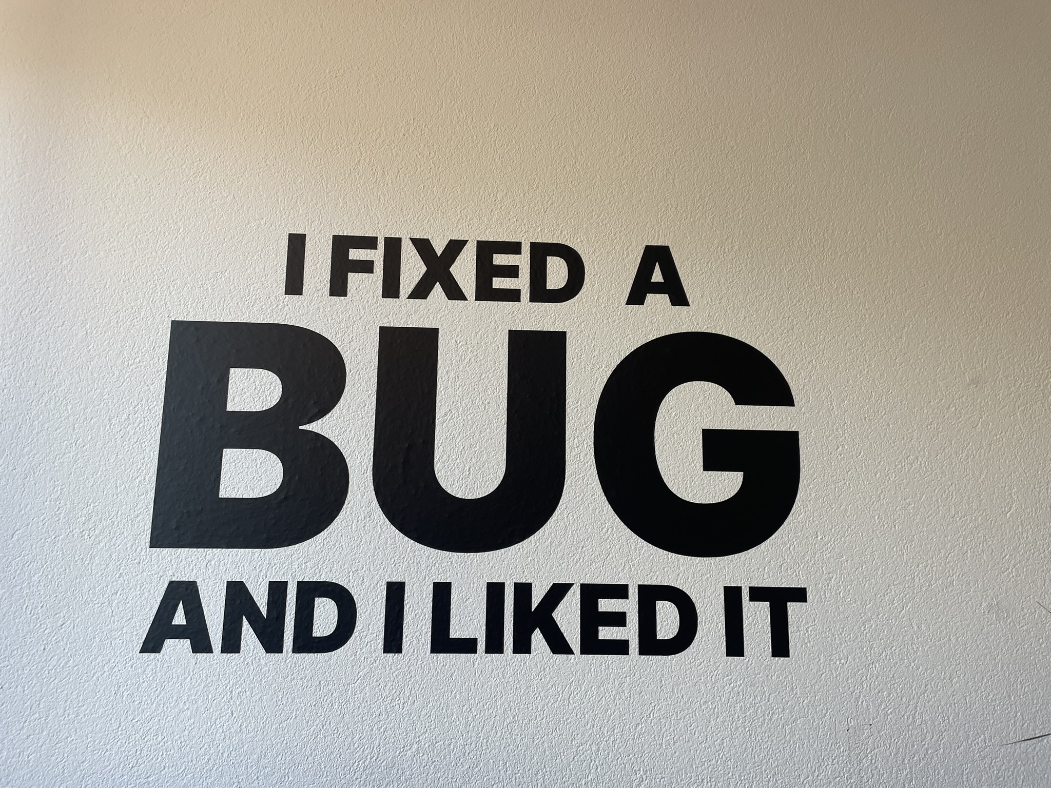 Wandtattoo an der Wand mit der Aufschrift I fixed a bug and I liked it