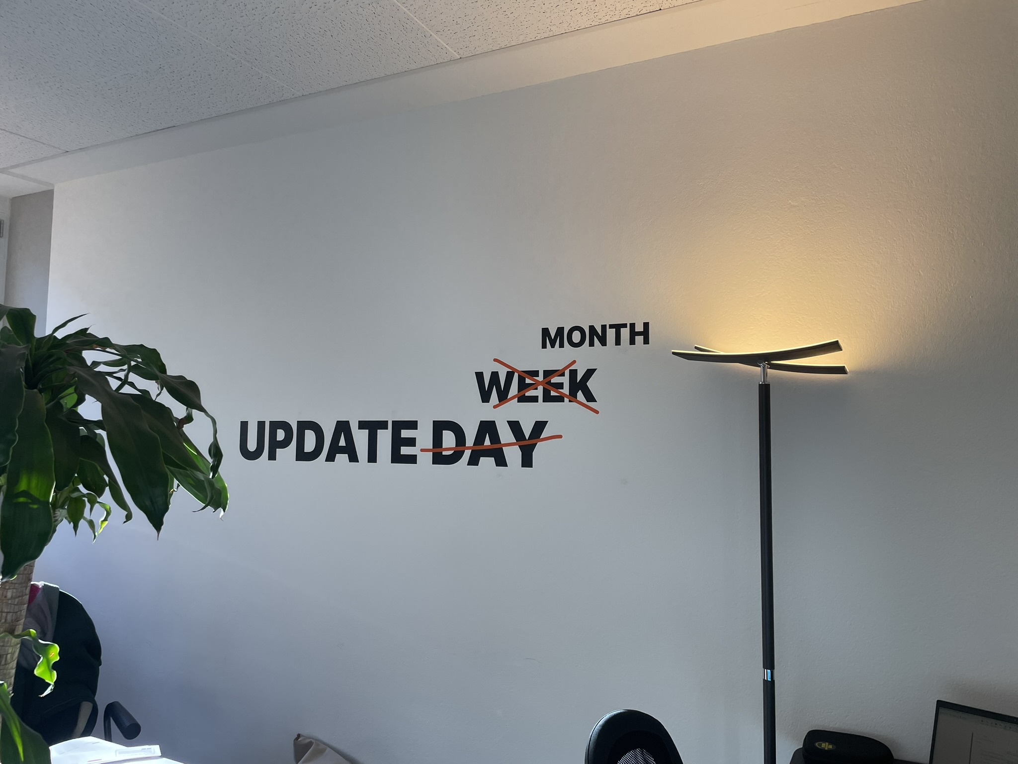 Wandtattoo an der Wand mit der Aufschrift Update Day Week Month (alles durchgestrichen bis auf Update und Month)