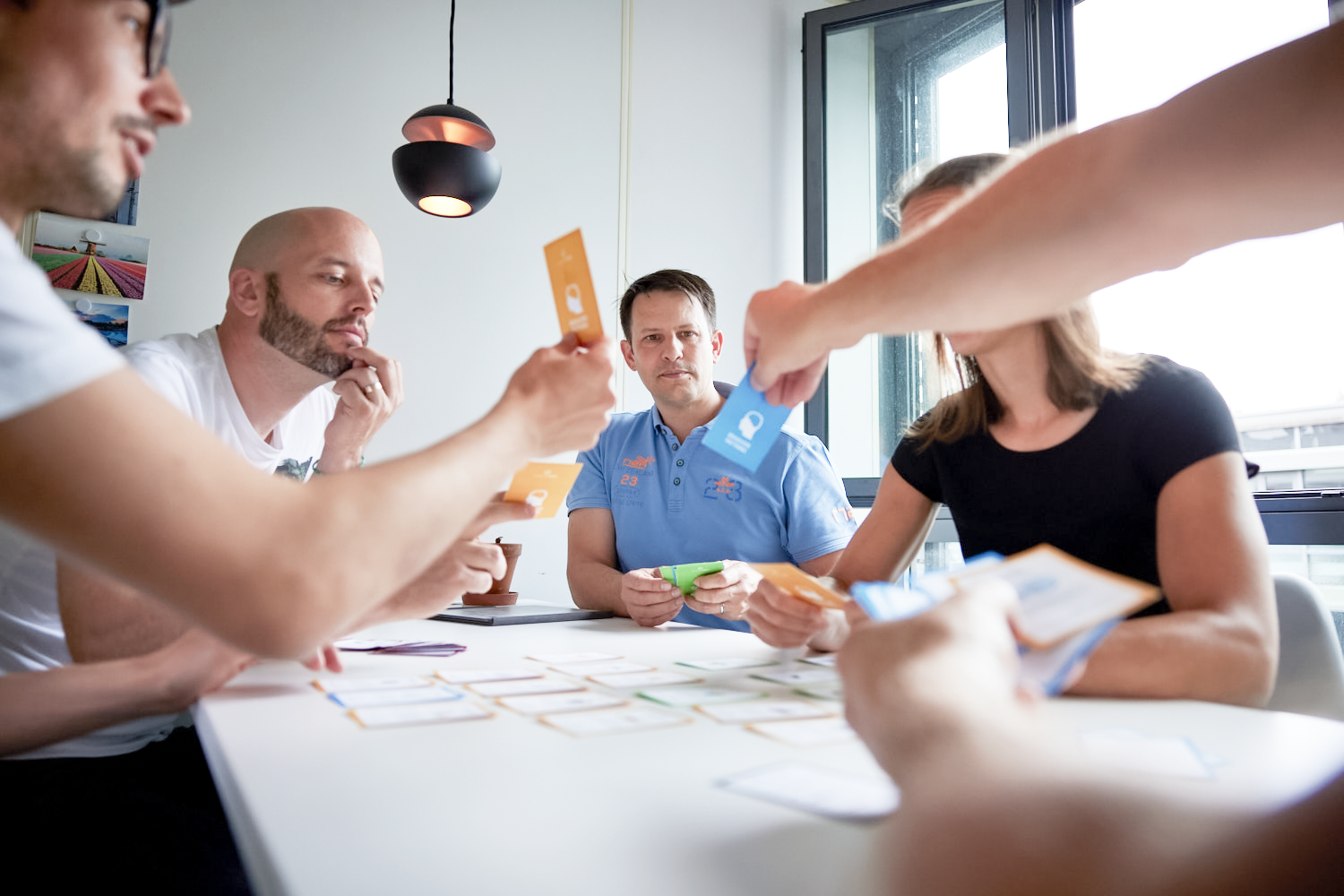 iqual Team an einem Tisch und überlegt, diskutiert